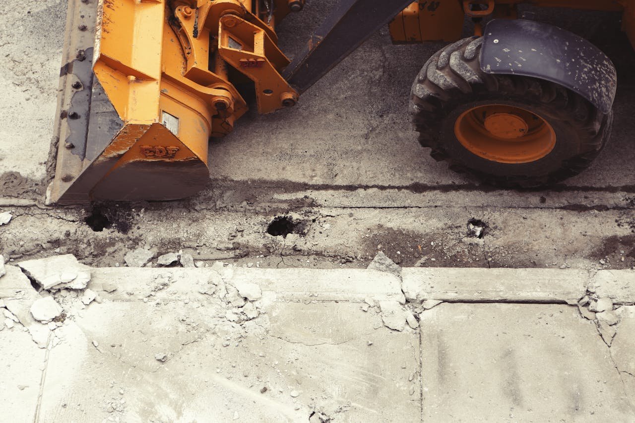 why-choose-us Close-up of an excavator working on road construction, showcasing the industrial process.